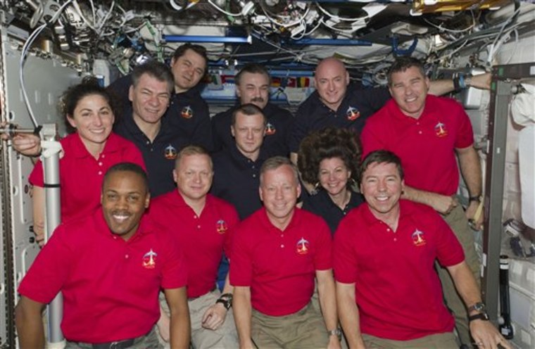In this March 3, 2011 photo provided by NASA, inside the U.S. lab Destiny, 12 astronauts and cosmonauts take a break from a very busy week aboard the International Space Station to pose for a joint STS-133/Expedition 26 group portrait. The STS-133 crew members, all attired in red shirts, from left, are NASA astronauts Nicole Stott, Alvin Drew, Eric Boe, Steve Lindsay, Michael Barratt and Steve Bowen. The dark blue-attired Expedition 26 crew members, from left, are European Space Agency astronaut Paolo Nespoli, along with Russian cosmonauts Oleg Skripochka, Dmitry Kondratyev, below, and Alexander Y. Kaleri and astronauts Scott Kelly and Cady Coleman, below. Serving the STS-133 and Expedition 26 missions as commanders were Lindsay and Kelly, respectively.